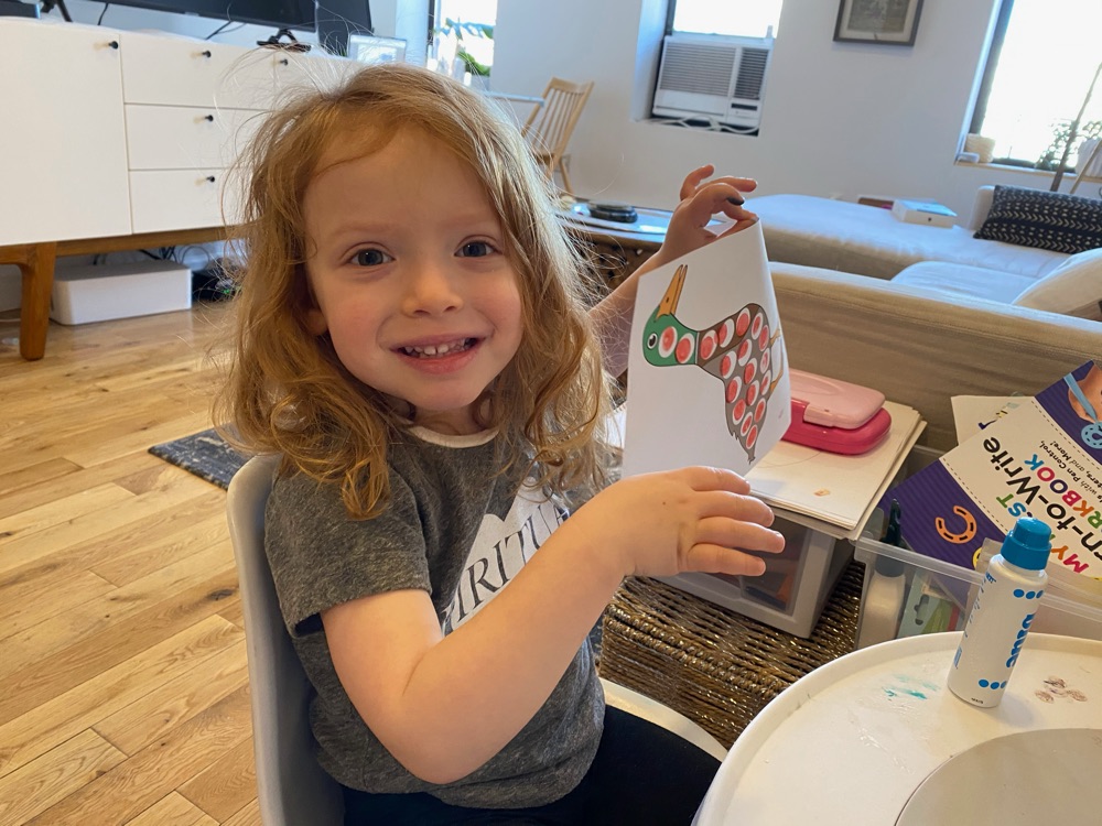Girl holding up a drawing she made