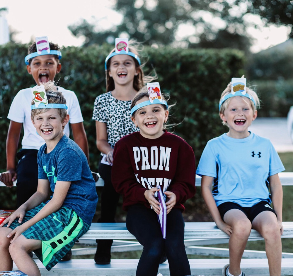 Group of children in paper crowns sitting on a bench