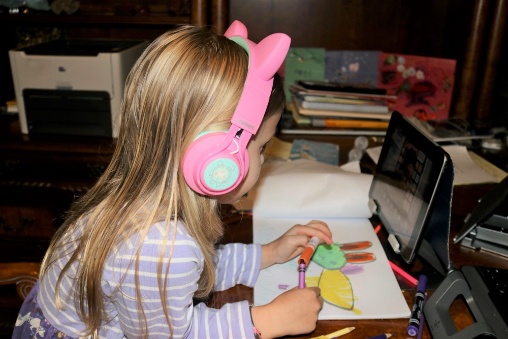 Girl in cat-ear headphones colouring during a session