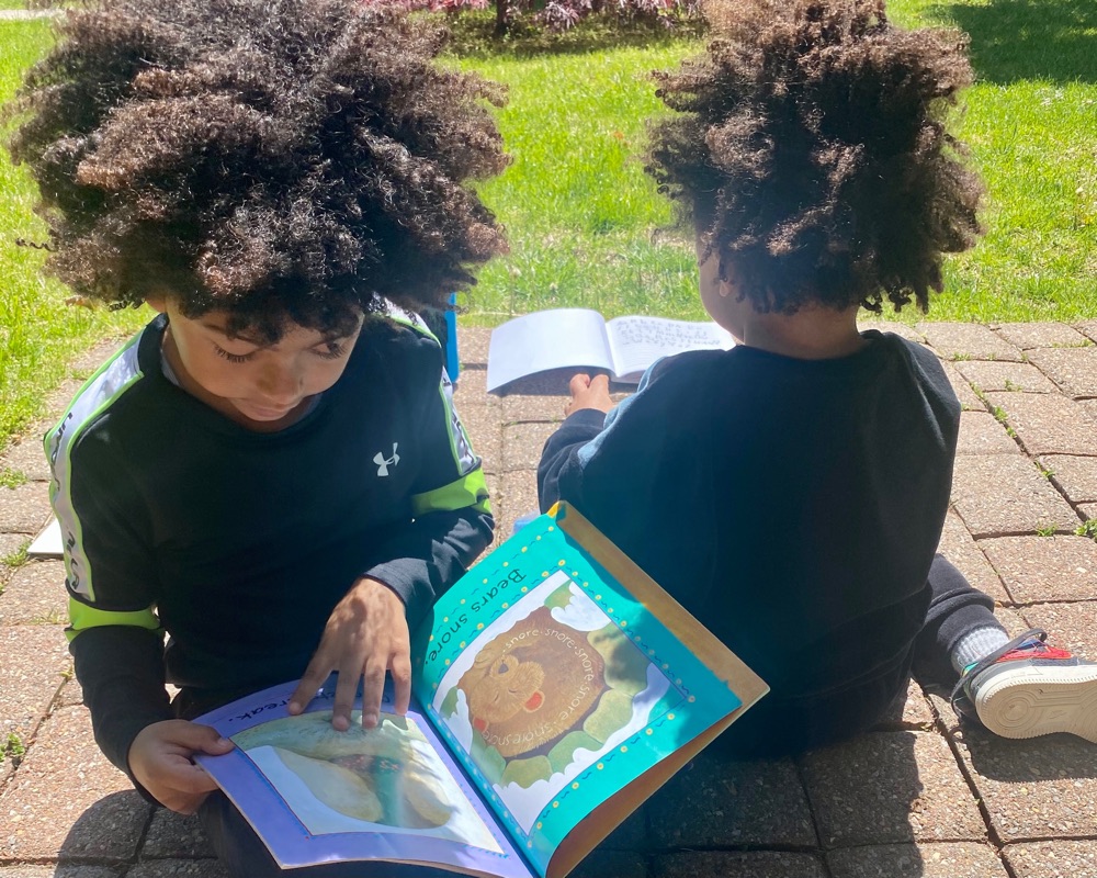 Boy reading a picture book outdoors